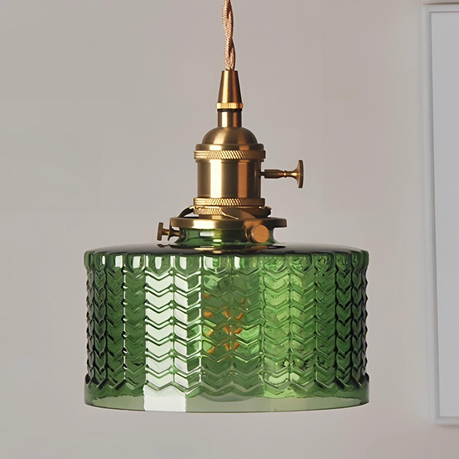 Vintage industrial glass pendant light with green shade and brass fittings.