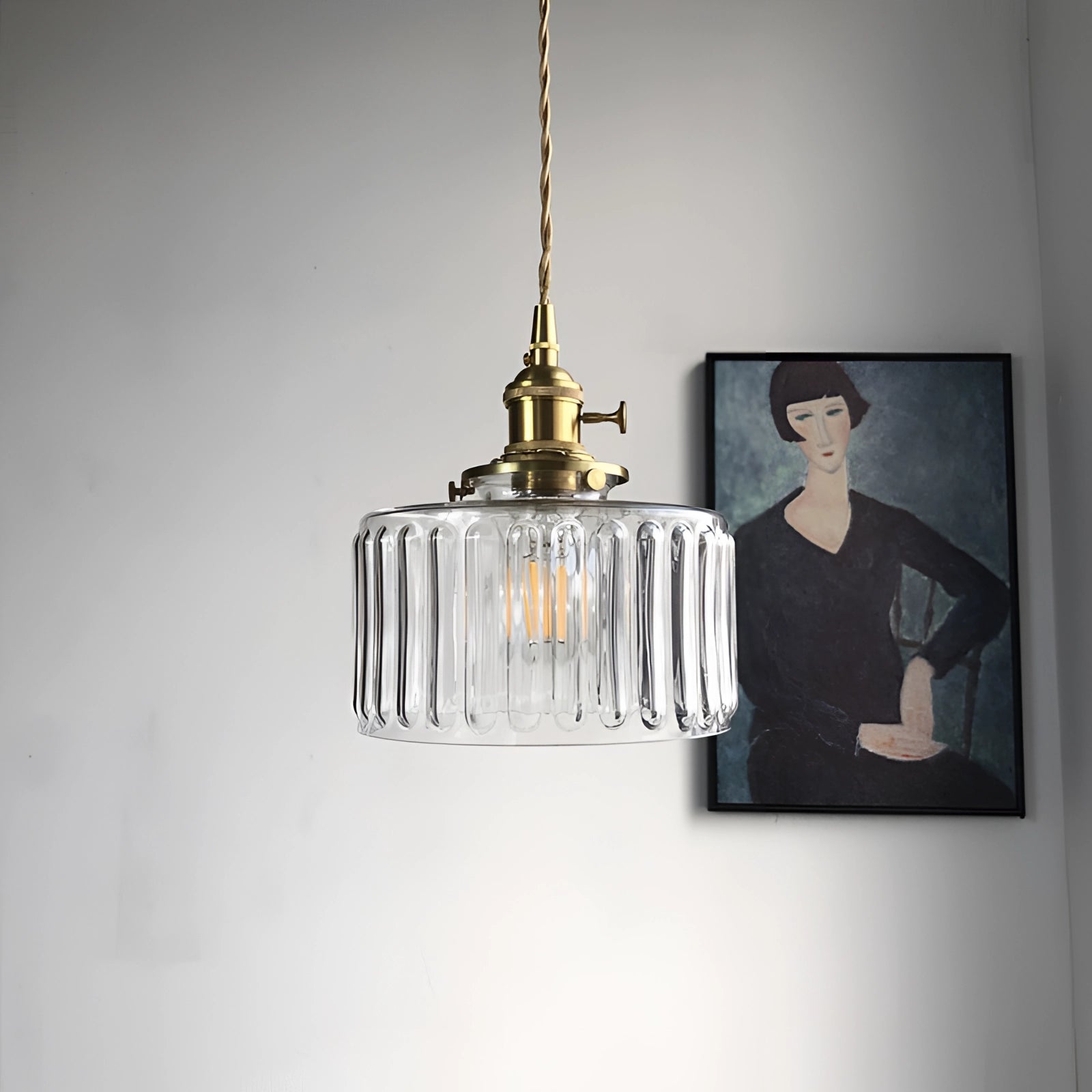 Vintage industrial green glass pendant light with brass fittings hanging from ceiling.