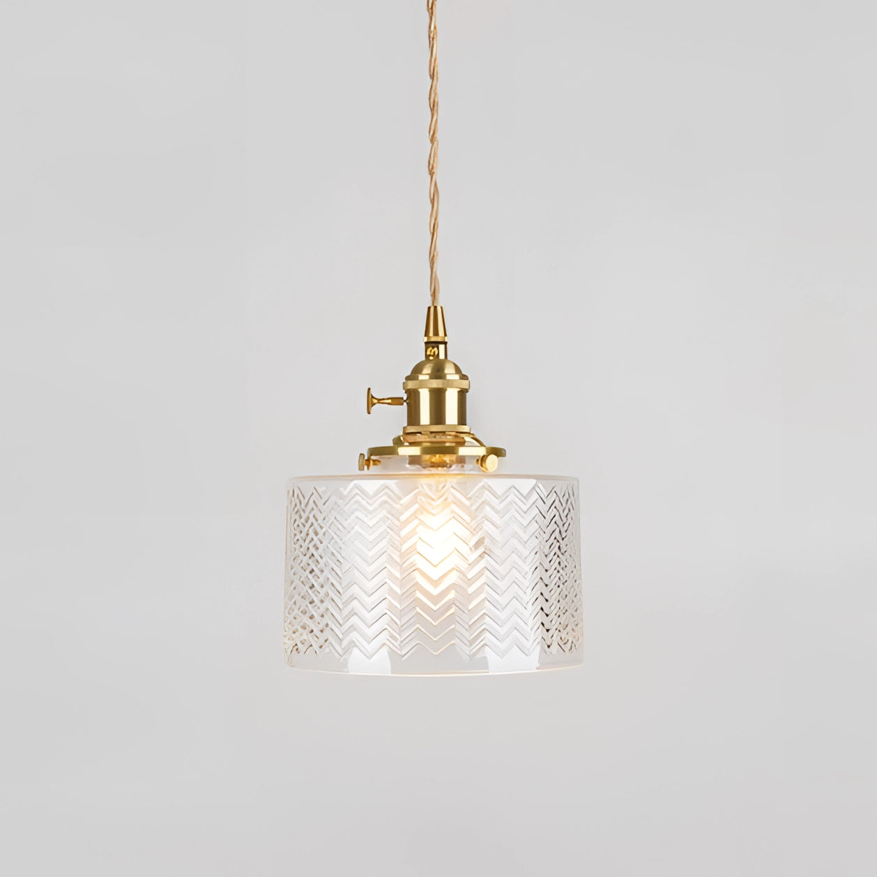 Vintage industrial glass pendant light with a green shade and brass fittings, hanging from the ceiling.