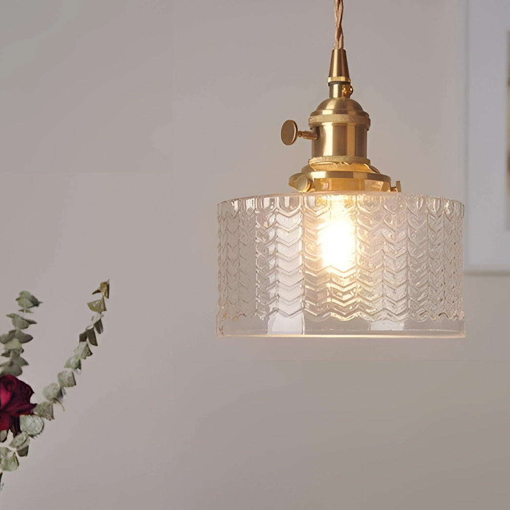 Vintage industrial glass pendant light with green shade and brass fittings, hanging from the ceiling.