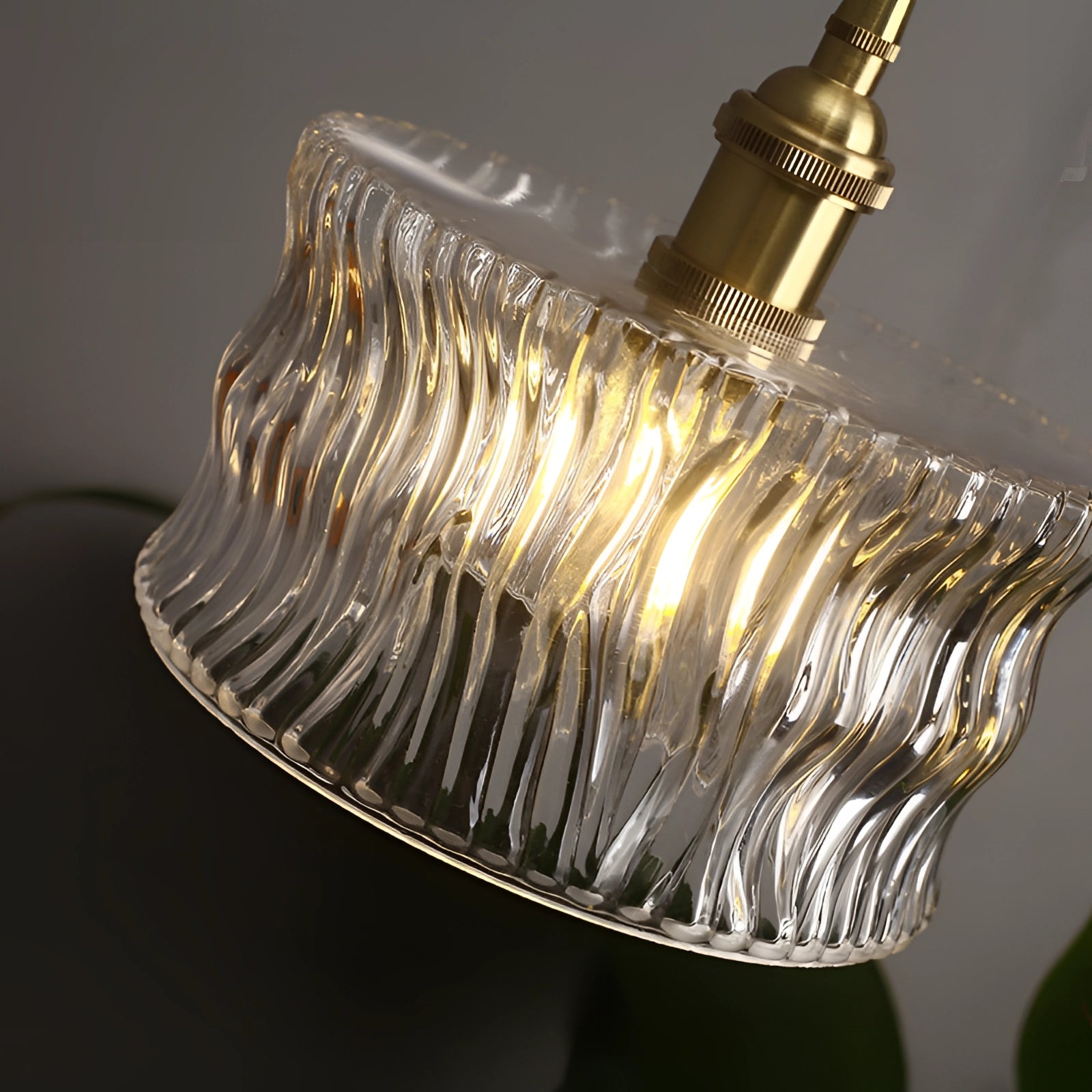Vintage industrial glass pendant light with a green shade and brass fittings hanging from the ceiling.