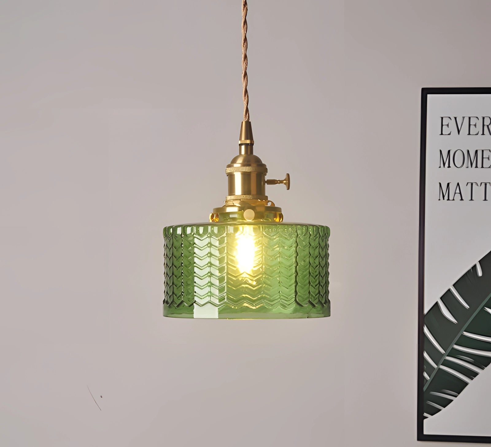 Vintage industrial glass pendant light with green shade and brass fittings, hanging as an interior lighting accessory.