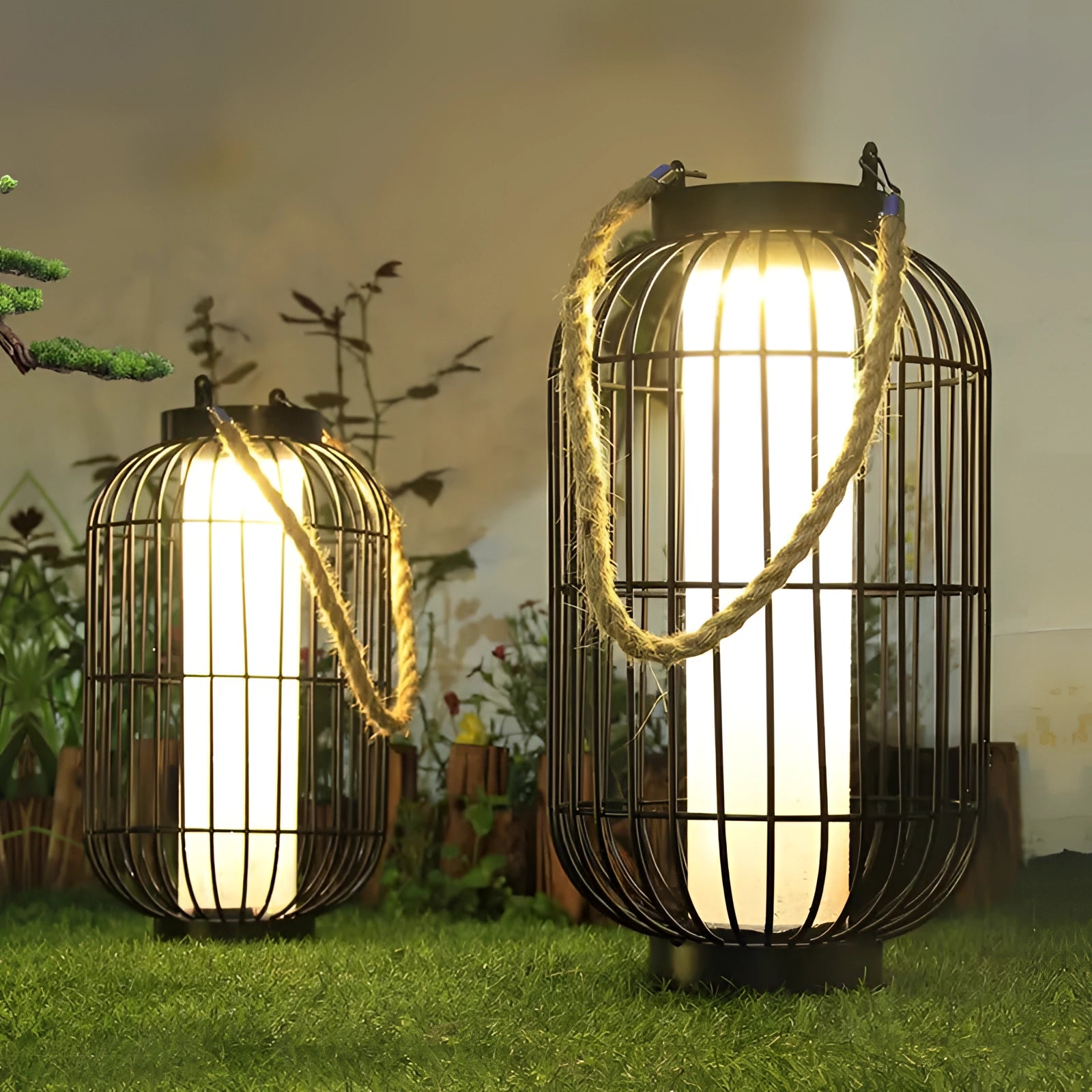 Vintage industrial table lamp with rustic metal lantern design and rope handle, placed on a wooden surface next to a potted plant.