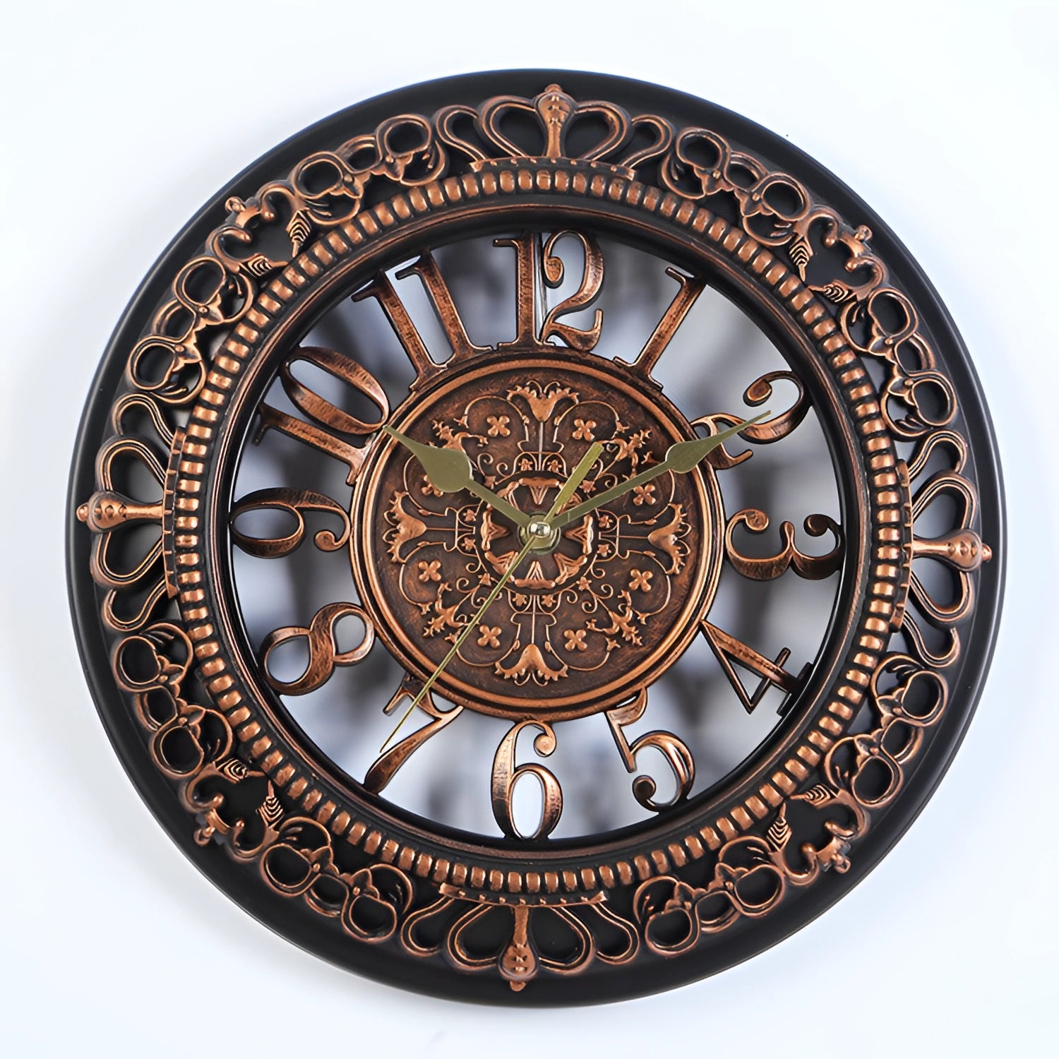 
A vintage ornate white wall clock with Roman numerals, featuring a copper finish and intricate patterns, designed in a circular shape.