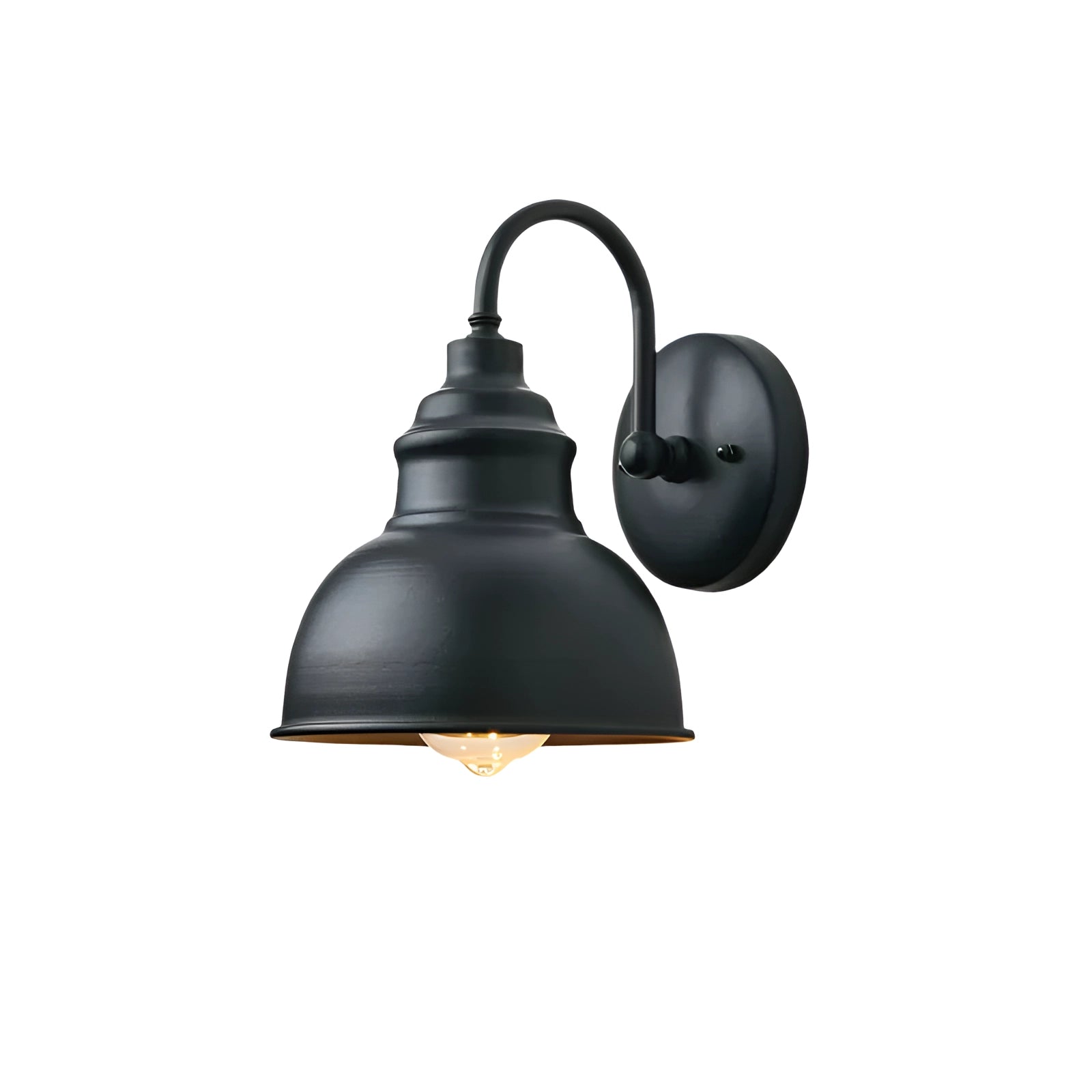 Warm white vintage outdoor wall sconce in antique bronze finish with a classic lantern design, mounted on a black metal fixture, illuminating against a backdrop of trees.