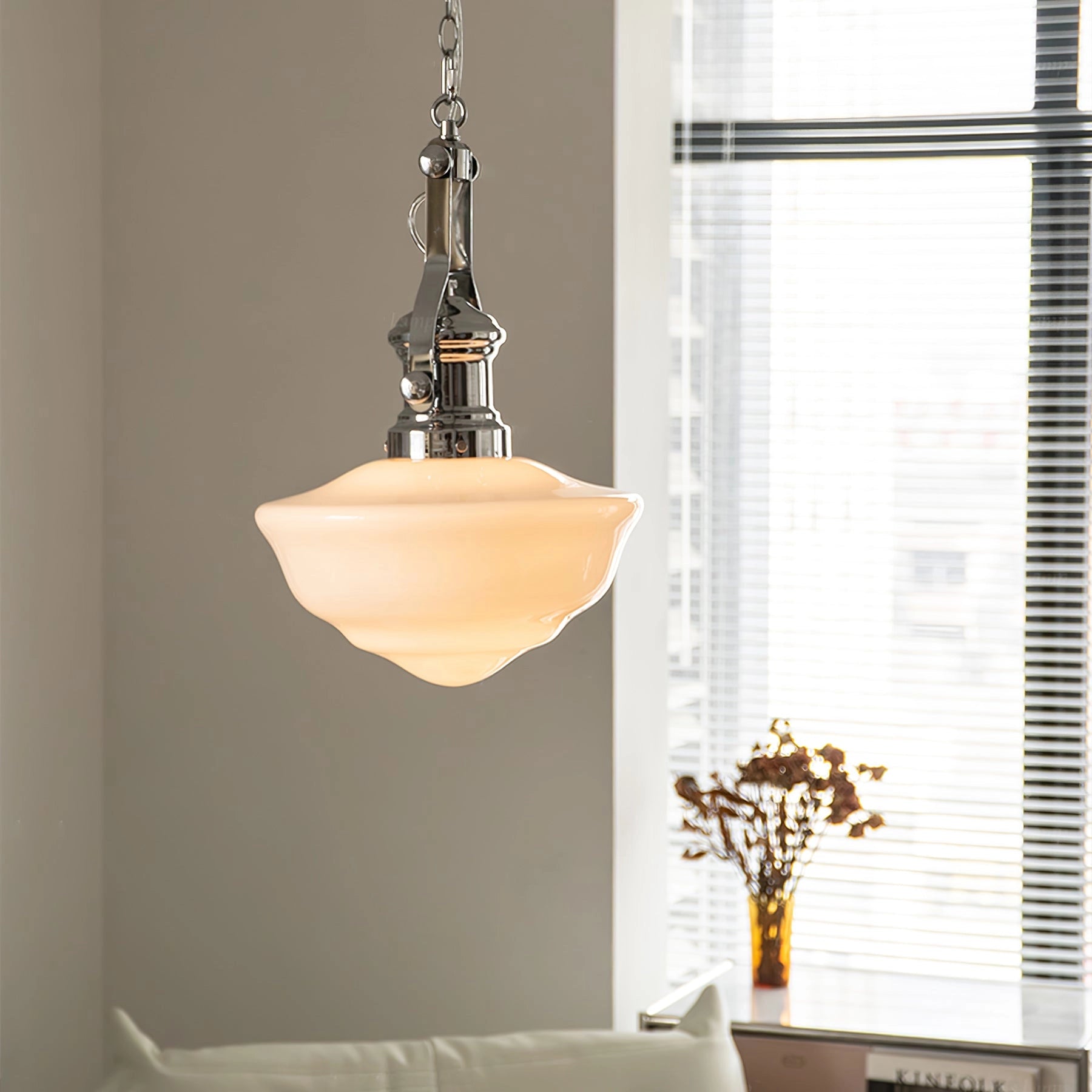 Vintage industrial retro glass pendant light hanging from the ceiling in a stylish interior setting with houseplants and decorative elements.