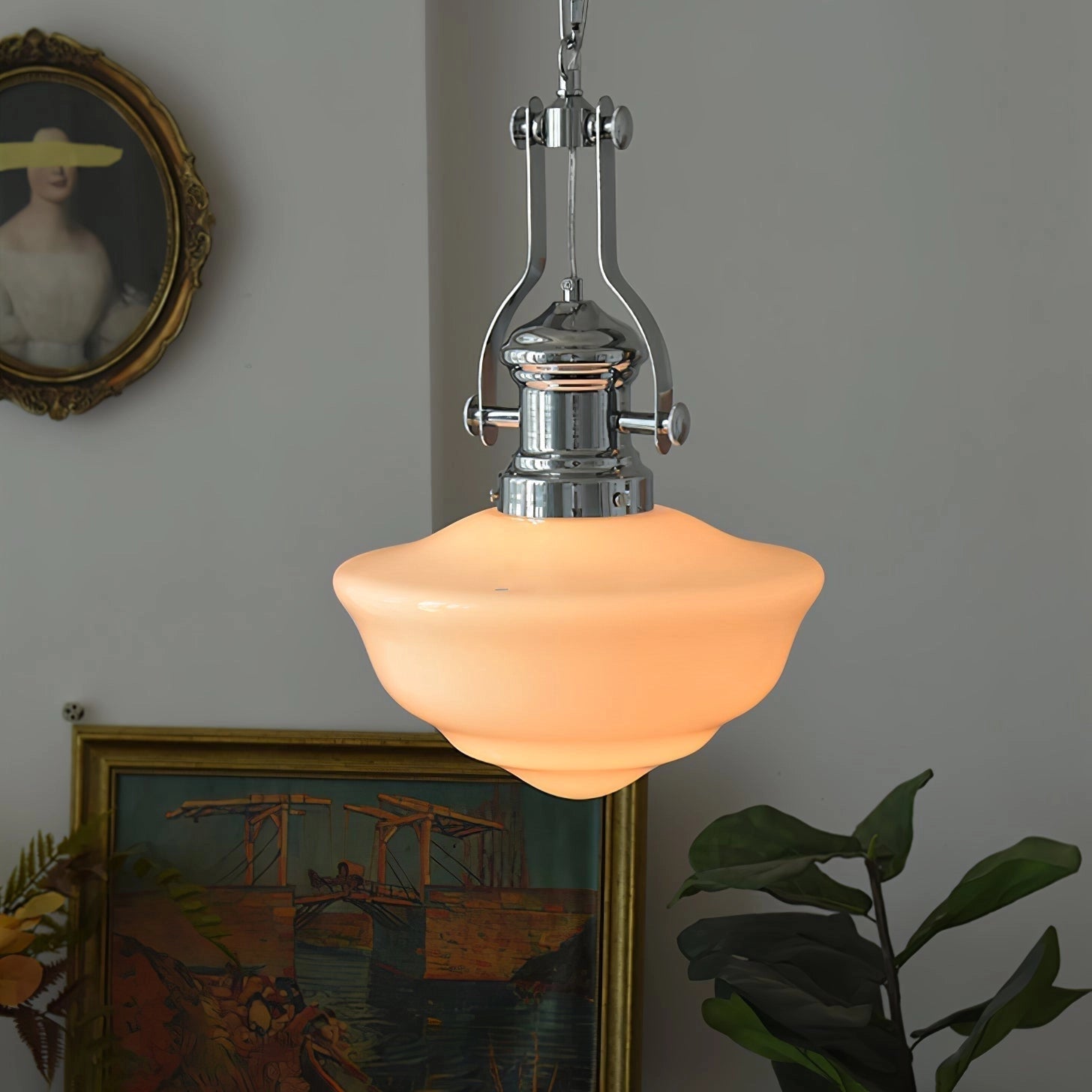 Vintage pendant light with an industrial retro design, featuring a glass lampshade. It is suspended from the ceiling and emits a warm glow, complementing the art deco style. The surrounding setting includes wooden elements and picture frames, creating a cozy and stylish ambiance.