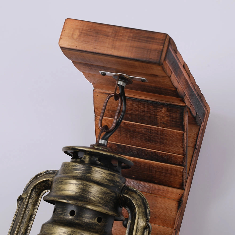 Vintage rustic lantern in antique brass, featuring a classic oil lamp design with metal and wood components. Ideal for nautical decor, this piece showcases a rectangular shape and a blend of materials, including hints of leather straps and antique detailing.