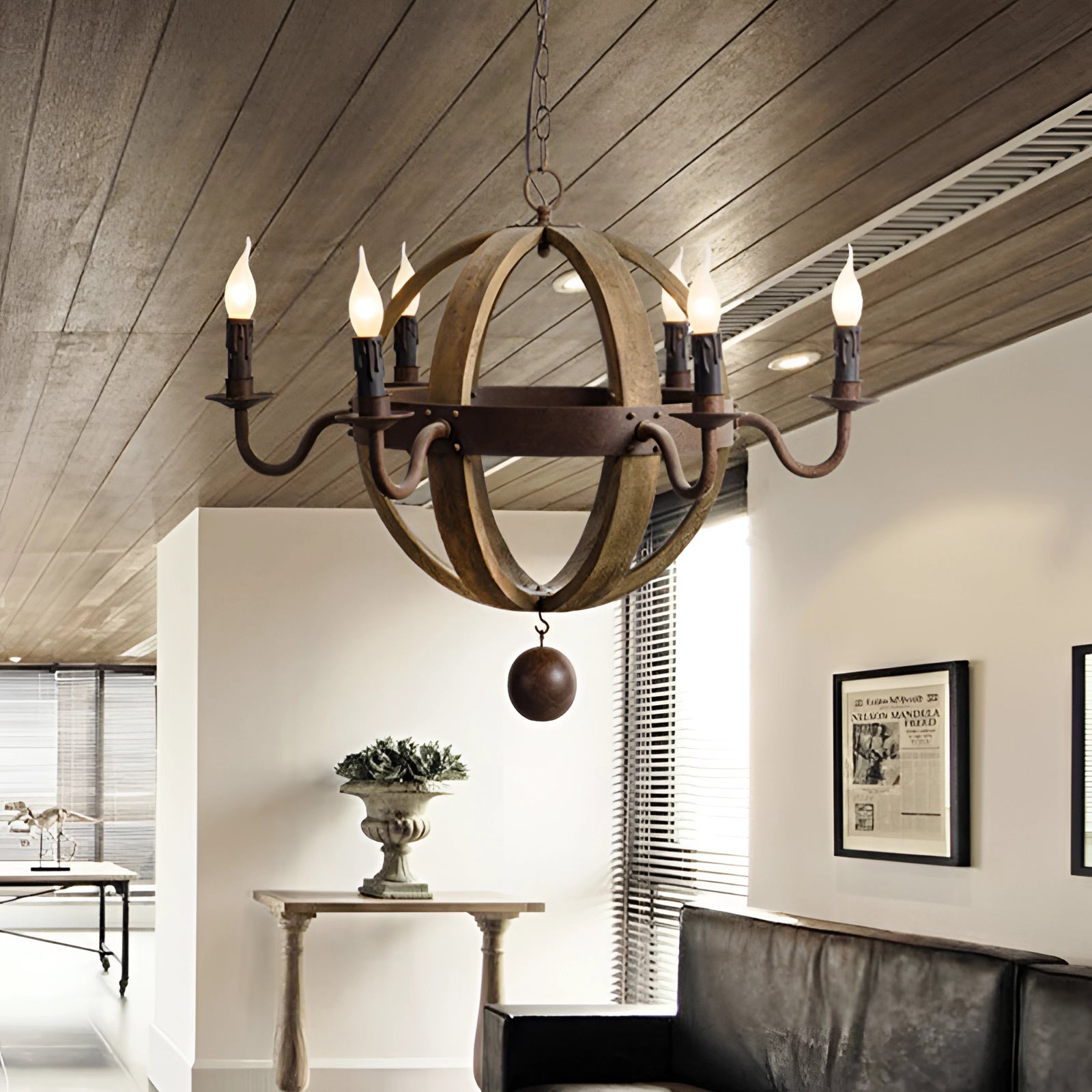 Vintage rustic pendant light featuring a farmhouse design with a wooden and metal chandelier, positioned in an interior setting with a table and plants, enhancing the cozy atmosphere with its warm lighting.