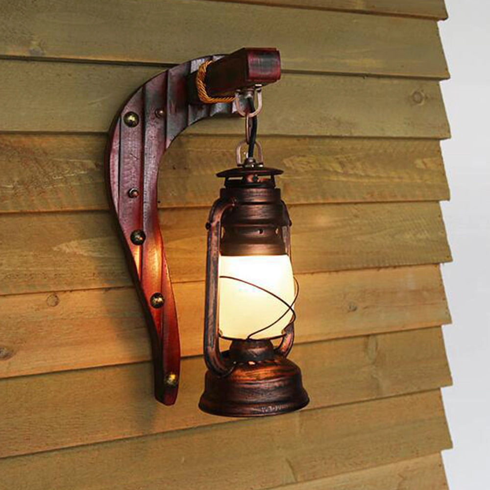 Vintage rustic wall lantern made of wood and metal, with an antique design featuring a gas lamp sconce, mounted on a wall next to a window.