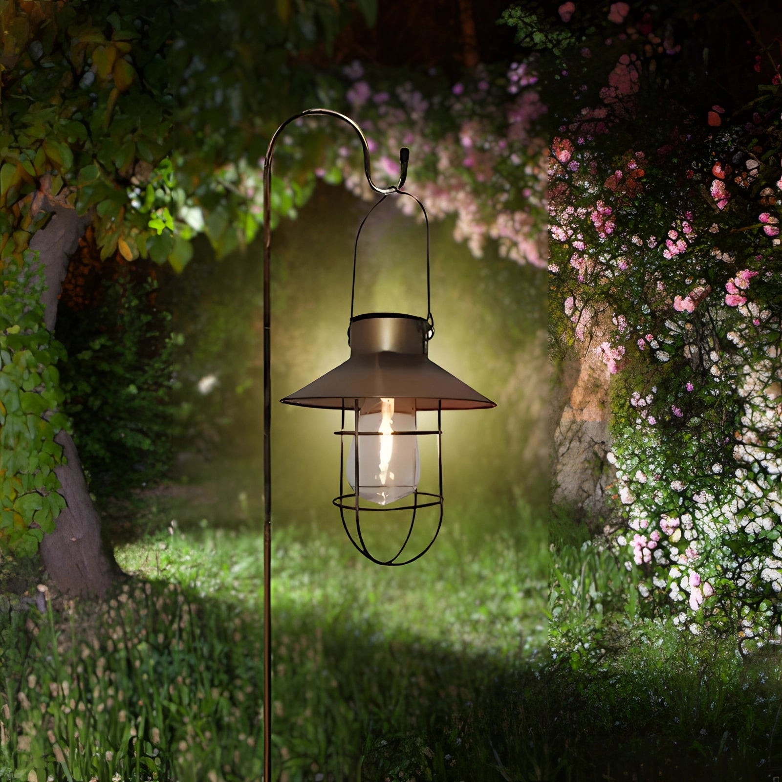 Vintage Solar LED Garden Lantern in bronze finish hanging amidst lush greenery, featuring a waterproof and eco-friendly design for outdoor use, surrounded by leaves and branches.