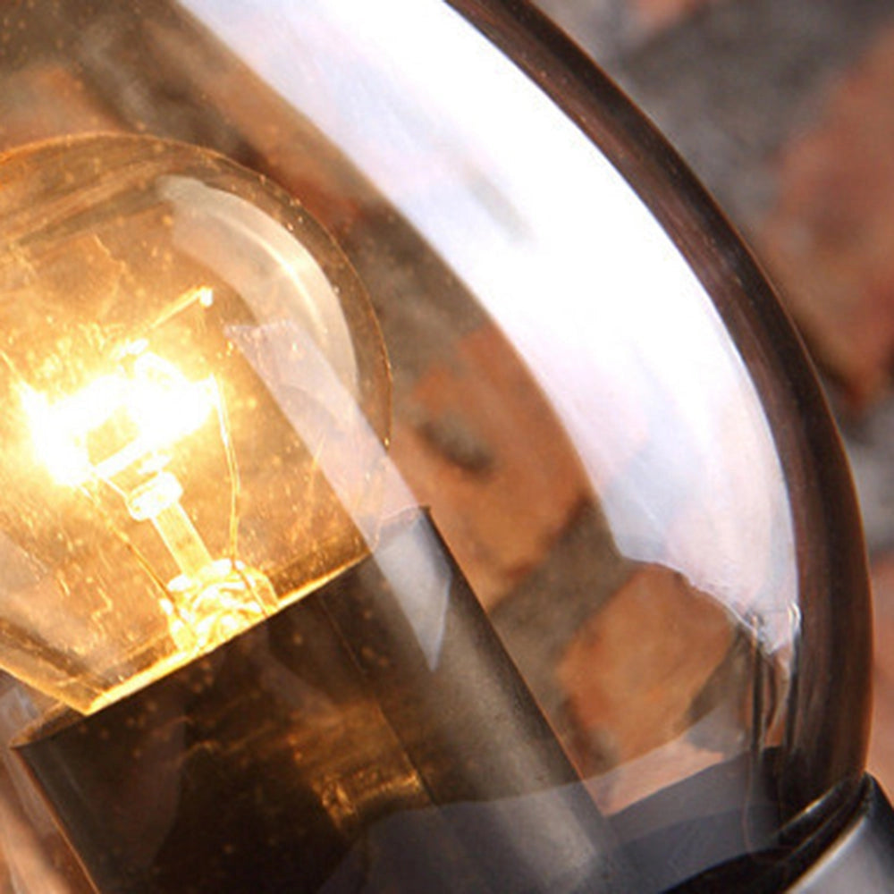 Vintage wall sconce with an antique lantern design, featuring rustic wrought iron craftsmanship, amber-tinted glass, and wood accents.
