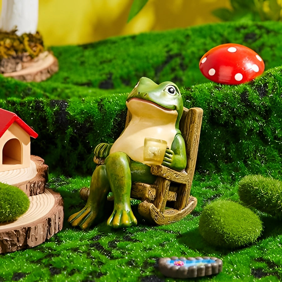 Whimsical green resin frog candle holder placed on grass with surrounding plants and greenery.