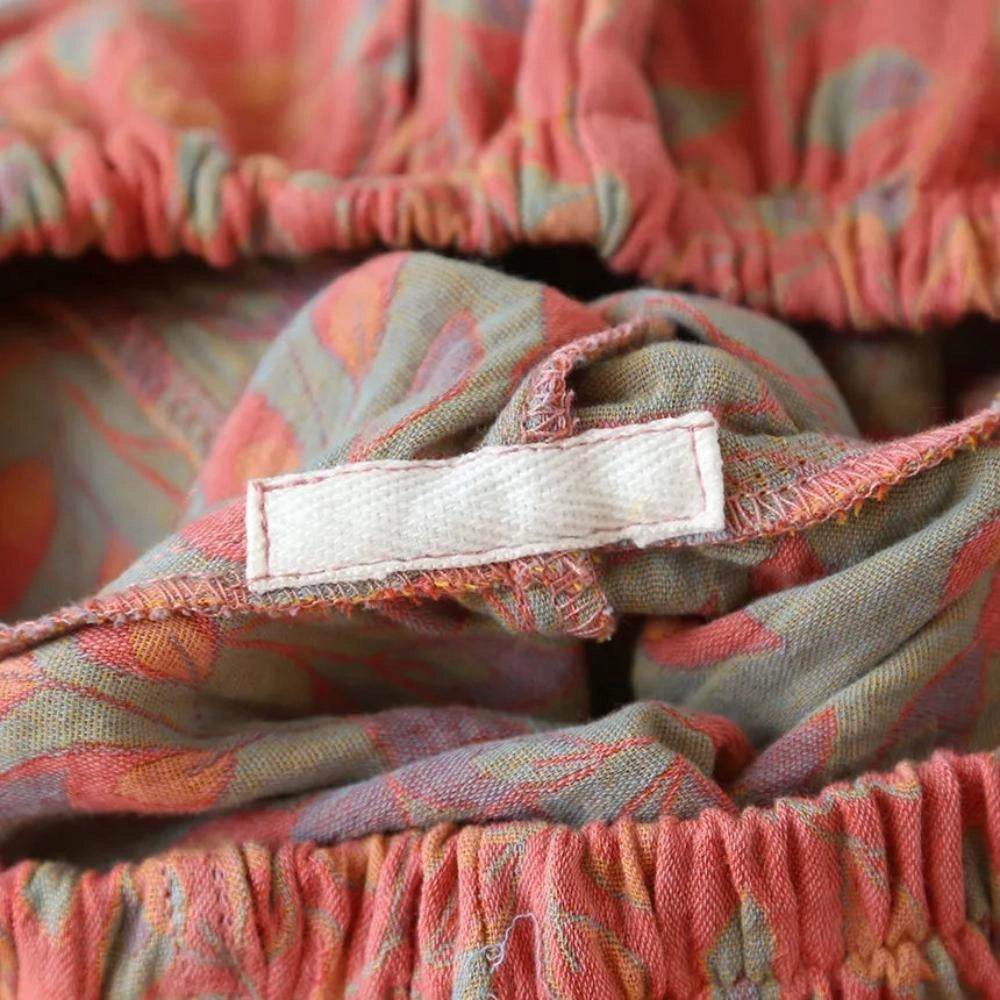 Women's floral print lightweight elastic waist casual shorts showcasing a vibrant orange and red plaid pattern with intricate textile details, highlighted in a close-up view.