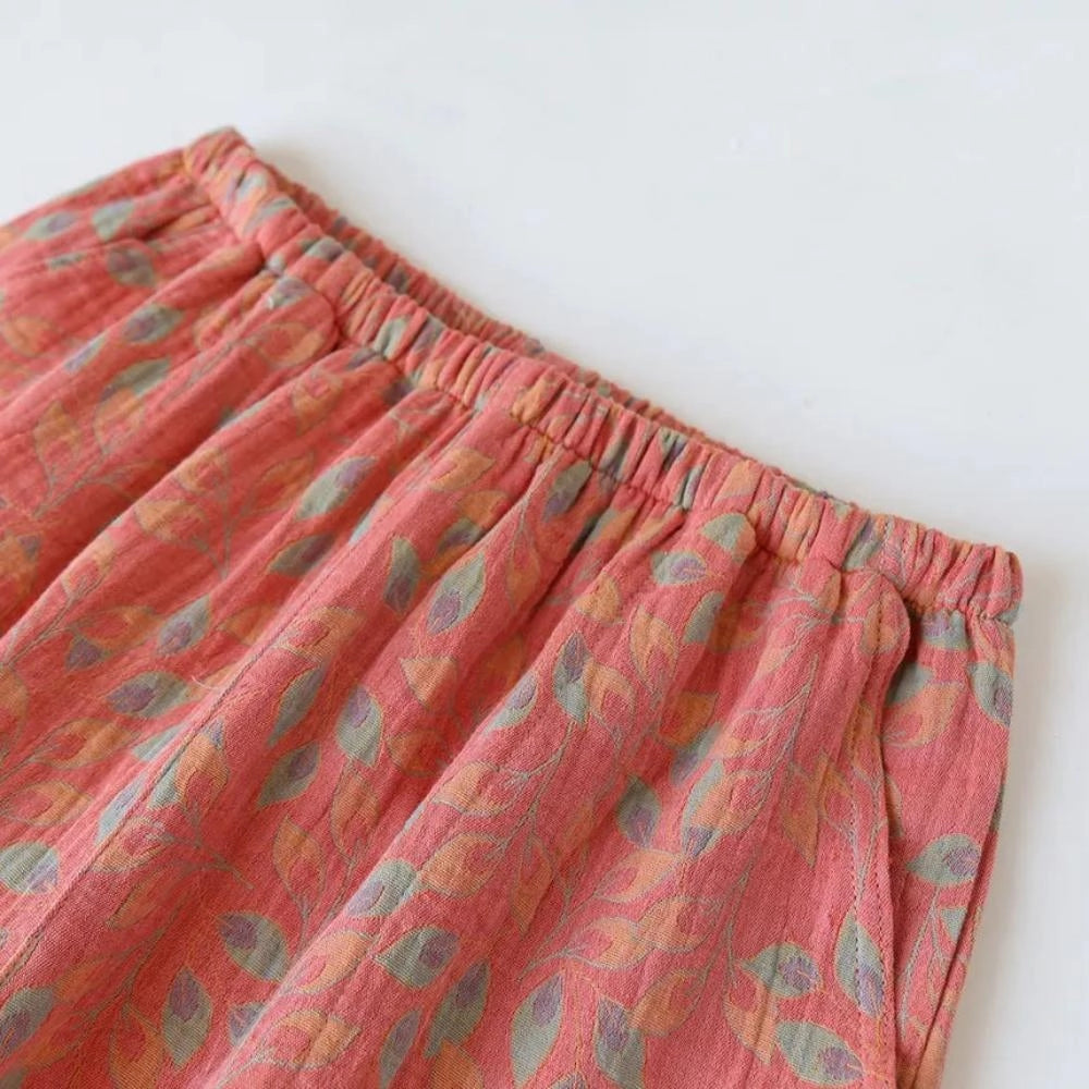 Women's floral print lightweight elastic waist casual shorts in pink and magenta hues displayed on a flat surface, showcasing the soft textile material and comfortable design.