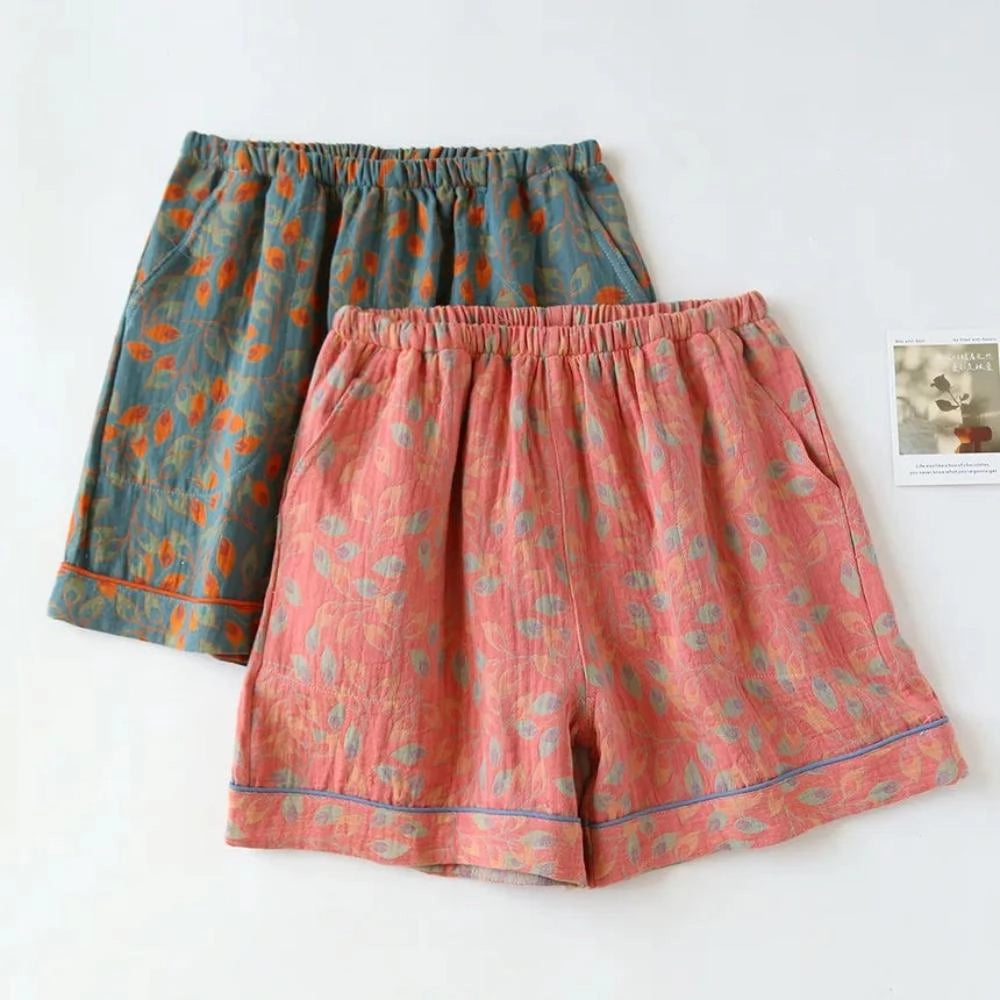 Women's floral print lightweight casual shorts with an elastic waistband, featuring a vibrant mix of orange and pink hues.