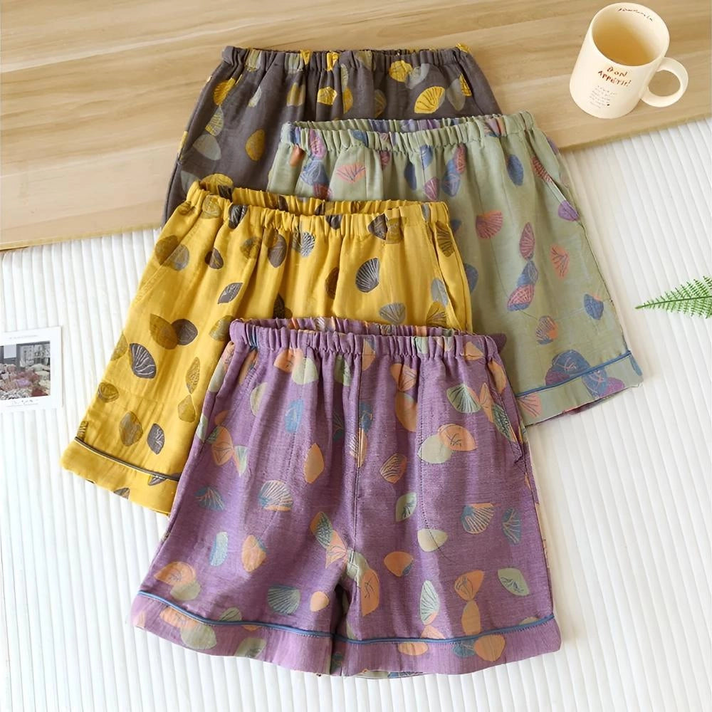 Women's colorful leaf print elastic waist summer shorts hanging on a clothes hanger.