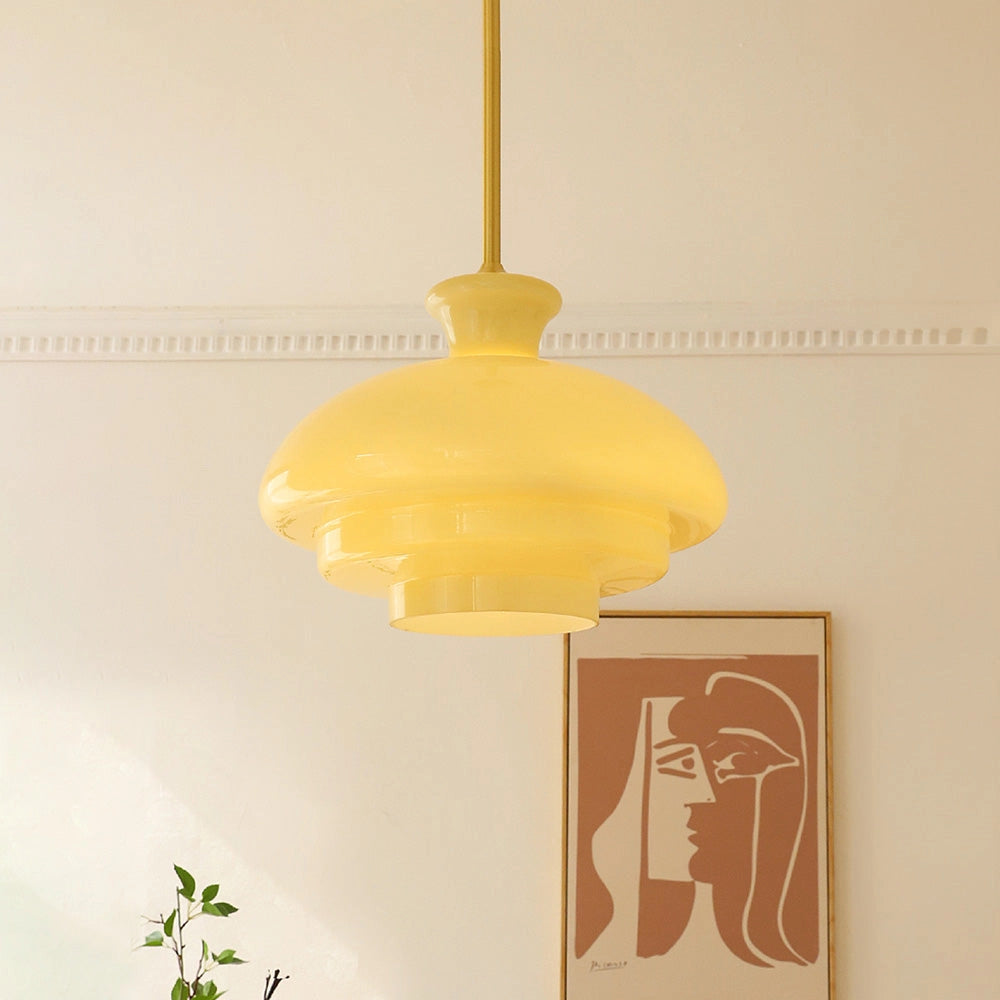 Modern Scandinavian minimalist yellow pendant light with amber glass shade and wooden accent, hanging from ceiling.