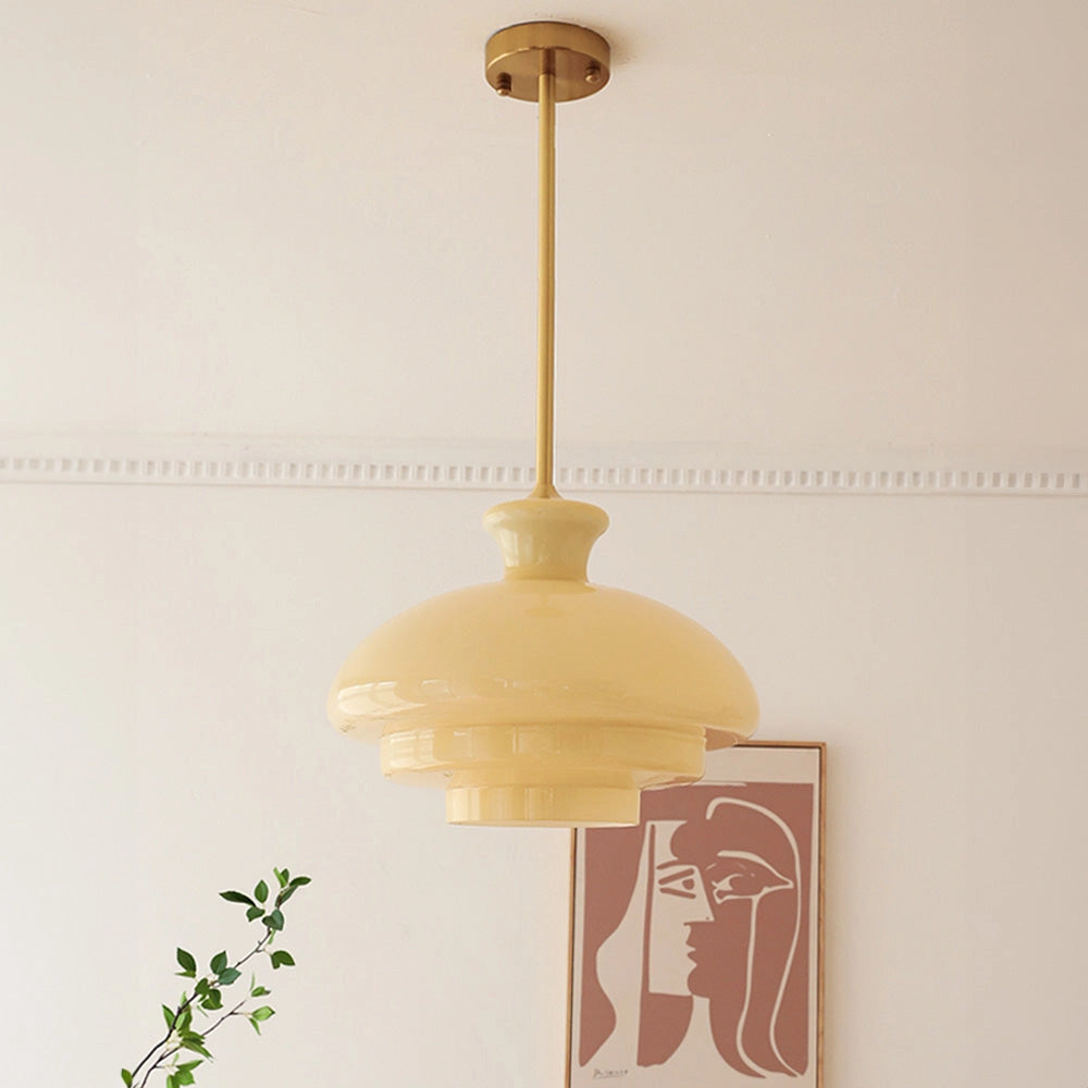 Modern Scandinavian minimalist yellow pendant light fixture hanging from ceiling, against a wooden wall background.