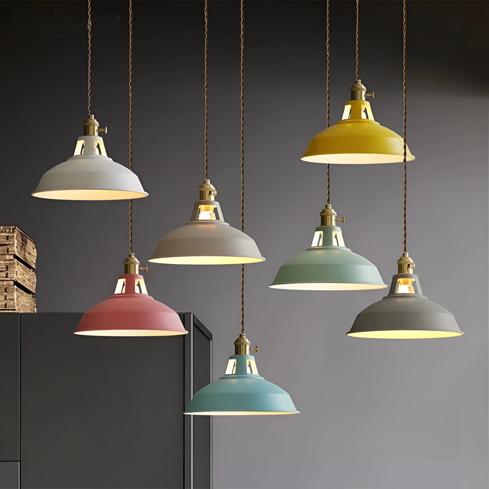 Yellow vintage dome pendant light with brass accents hanging from a ceiling, showcasing industrial-style design and casting warm illumination.